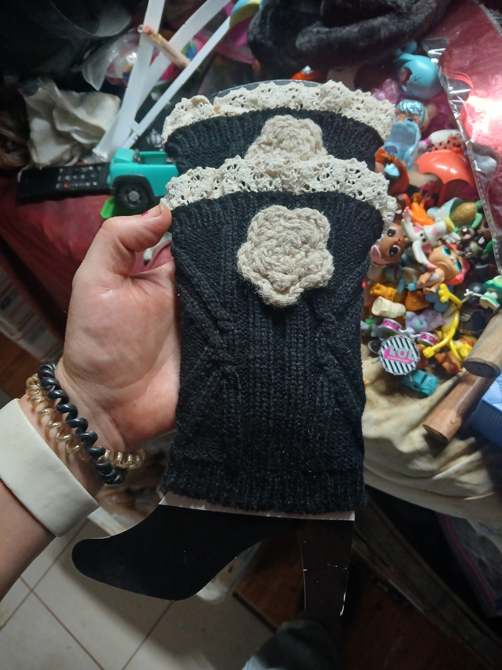pair of black knit leg warmers or boot cuffs featuring beige crochet lace trim